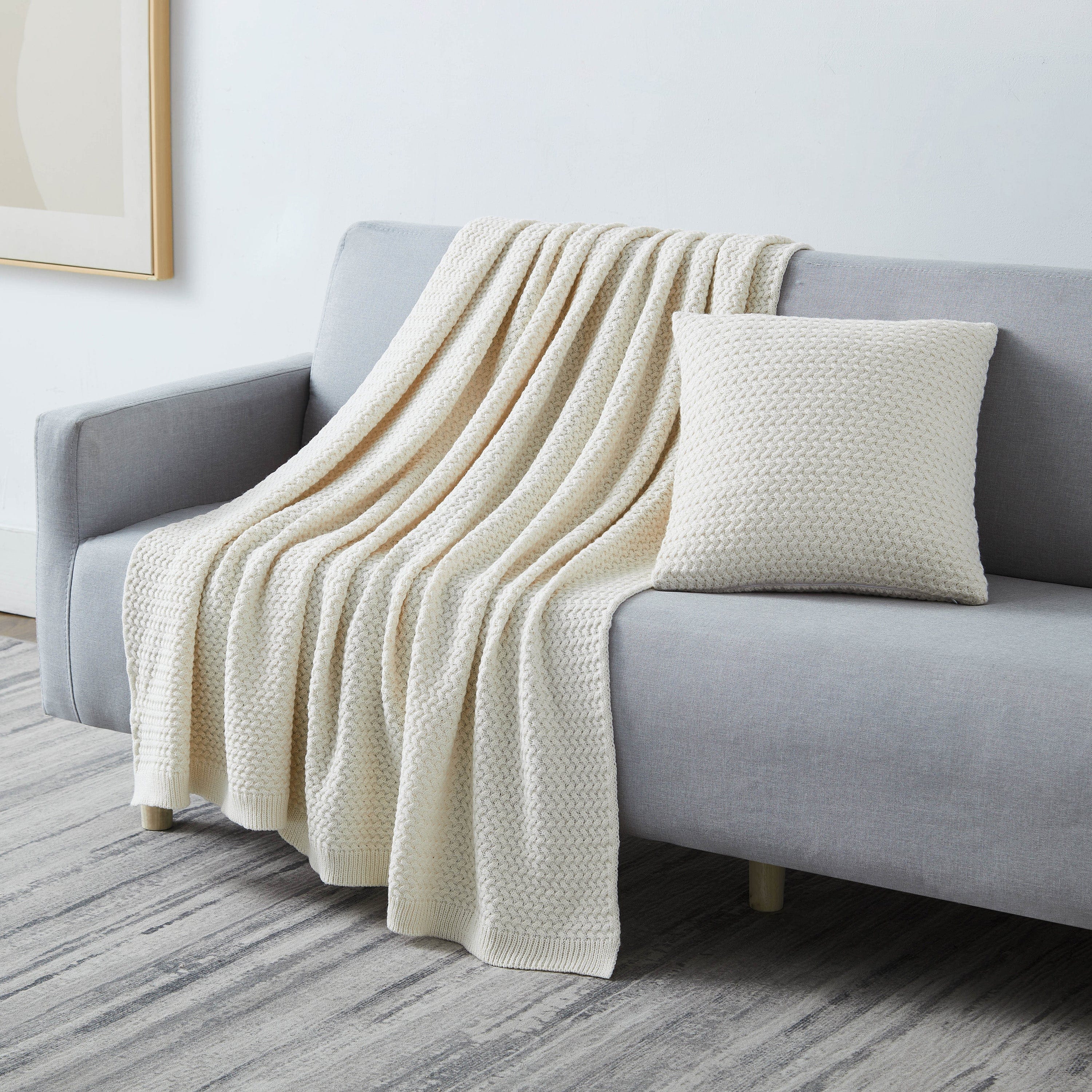 Angled View of Arcylic Throw Set in Taupe on Sofa#color_acrylic-taupe