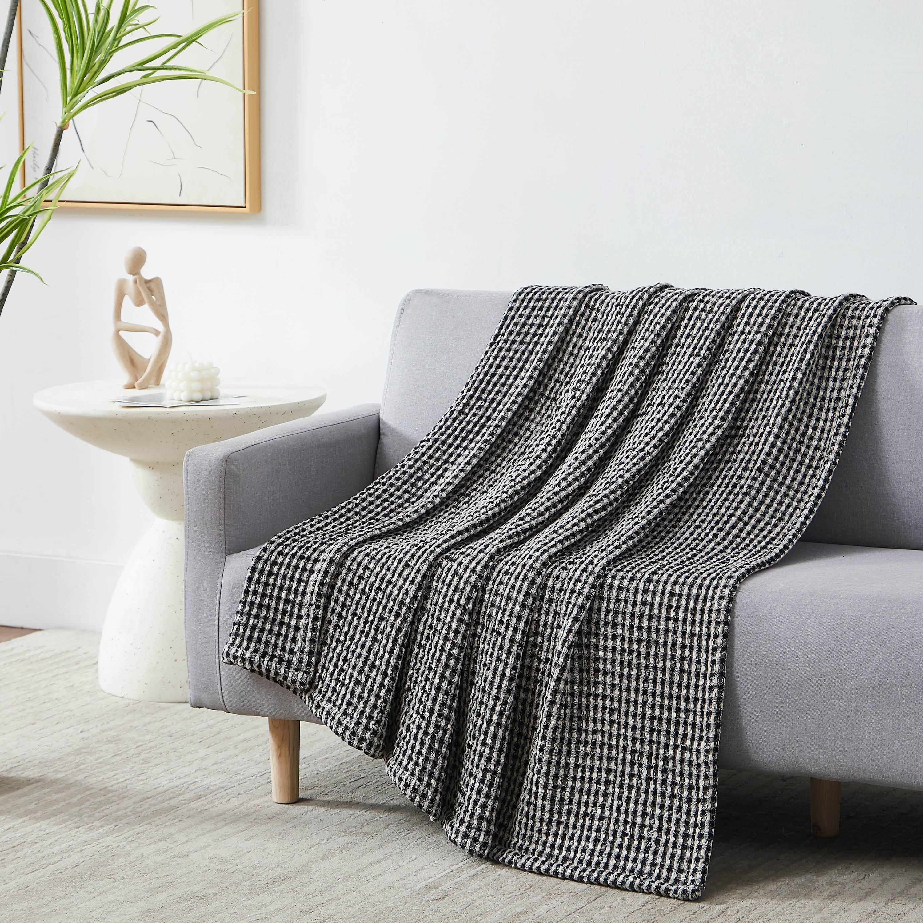 Tama Cotton Blanket and Throw in black on sofa#color_tama-black