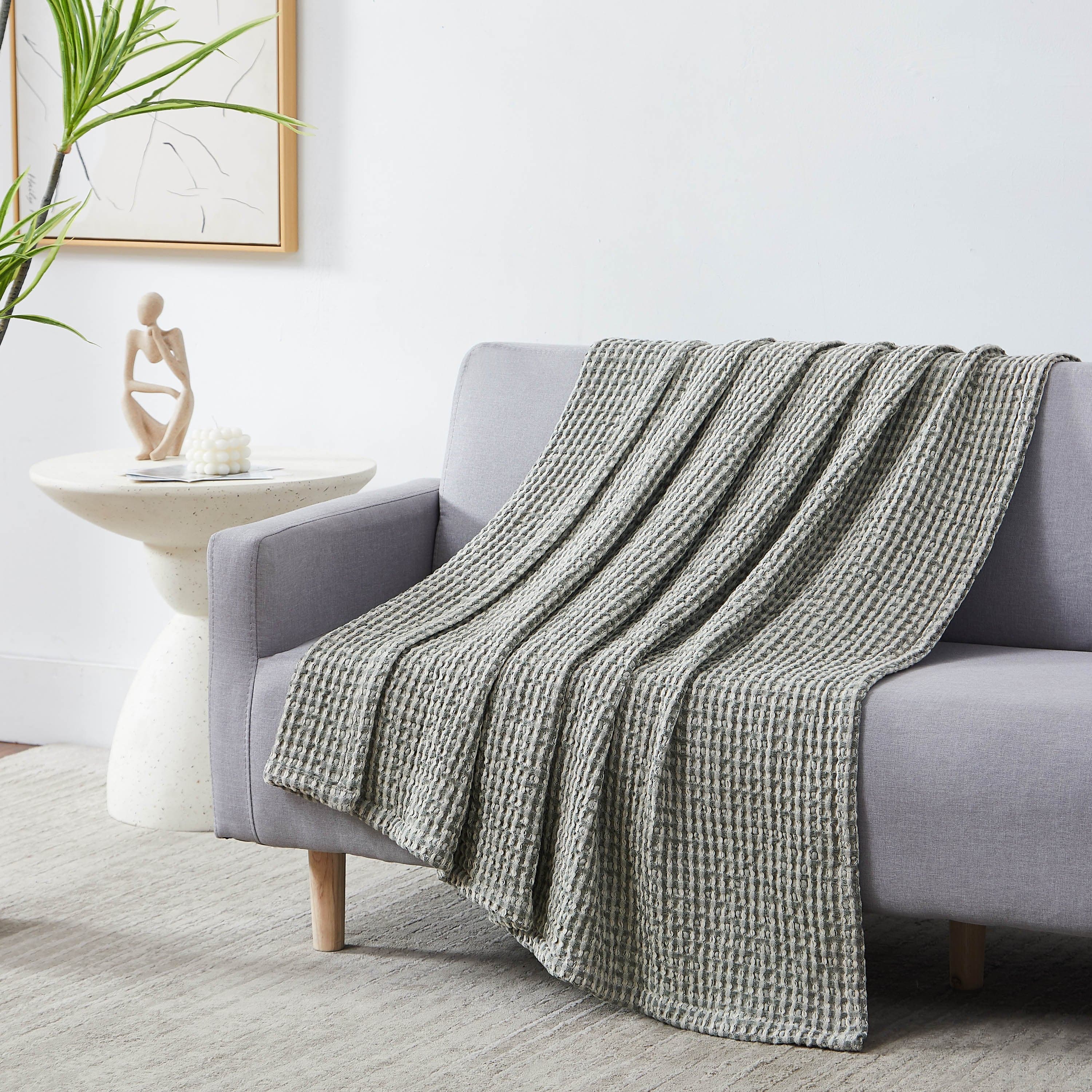Tama Cotton Blanket and Throw in green on sofa#color_tama-green