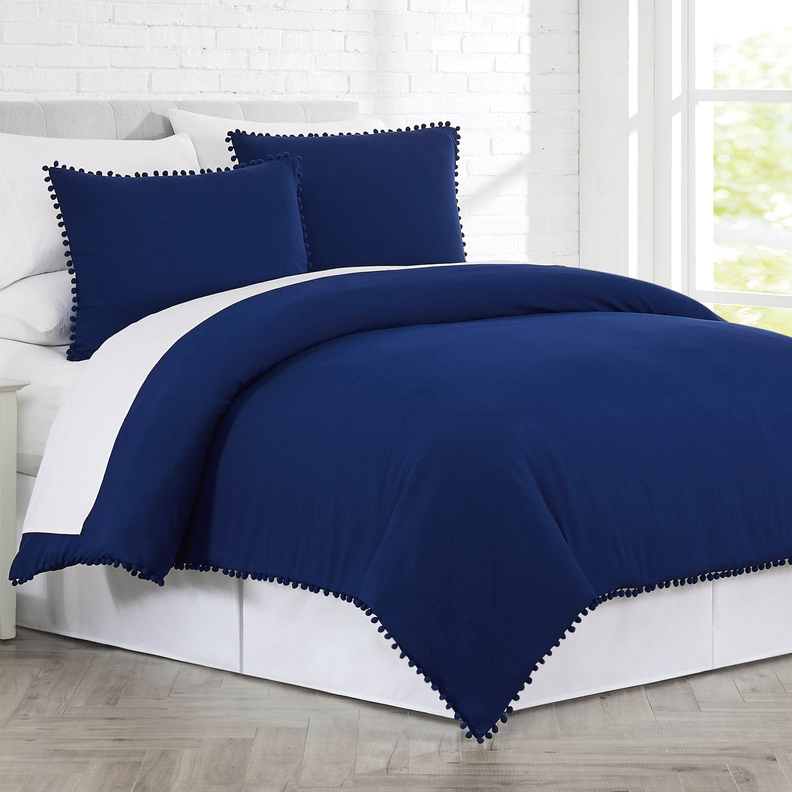 Side View of Pom-Pom Duvet Cover Set in Navy Blue#color_navy-blue