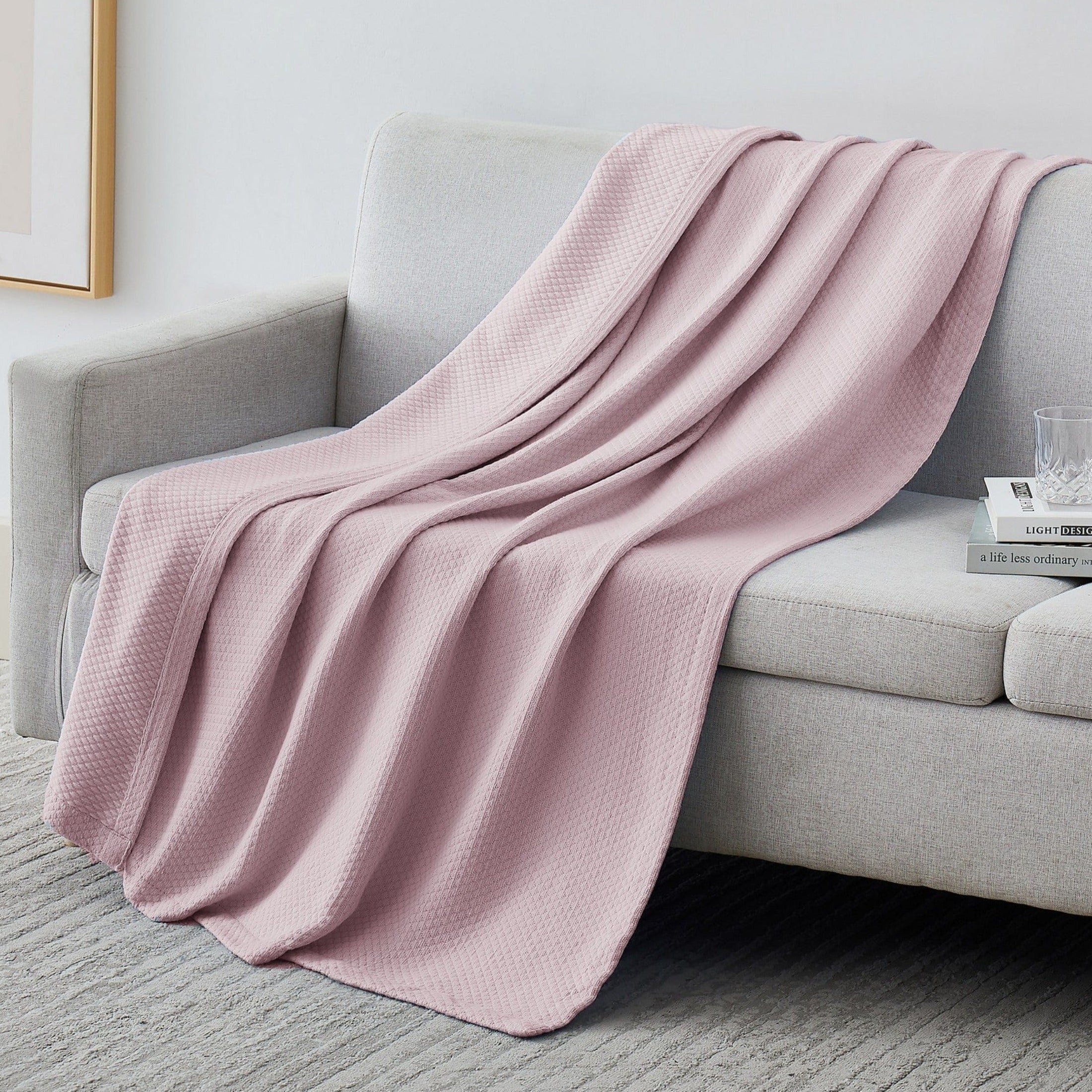 Milton Cotton Blankets and Throws in Pink on Sofa#color_milton-pink